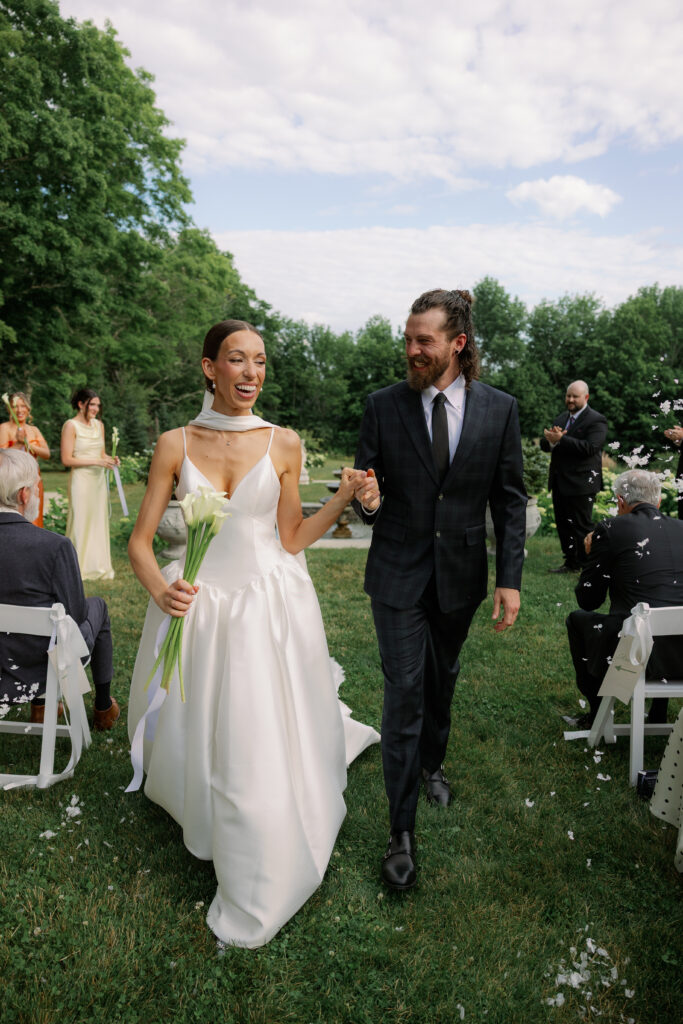 bride and groom walk back down the aisle together at Belvedere House and Garden