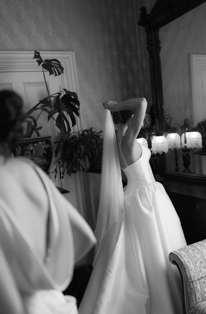 bride puts on veil getting ready at Belvedere House and Garden